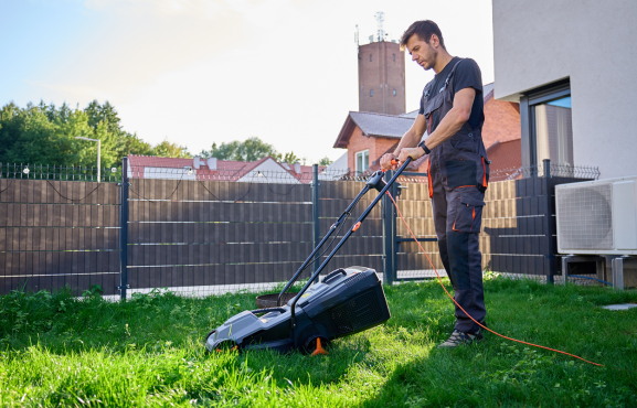 jardinier jdnet en train de tondre une pelouse